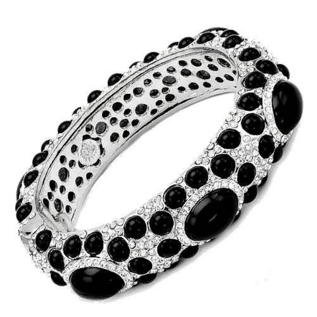 Angelique de Paris Onyx Swarovski Crystal Bracelet: Angelique de Paris Swarovski crystal & oynx bracelet. 7 larger ( 12.7mm ) & 68 smaller ( approx 4mm ) oval oynx cabochons, with inset round Swarovski crystals. Hinge opening.