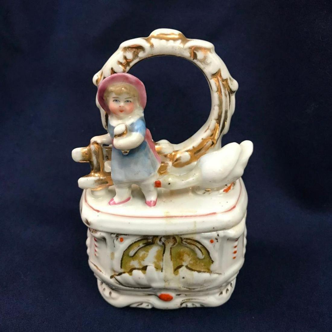 Antique German Conta Boehme Porcelain Fairing Box, Girl: Antique, late 19th-Century Victorian, Conta Boehme German porcelain fairing box, in the form of a goose biting at a little girl. 5" H X 3 1/4" W X 2" D.