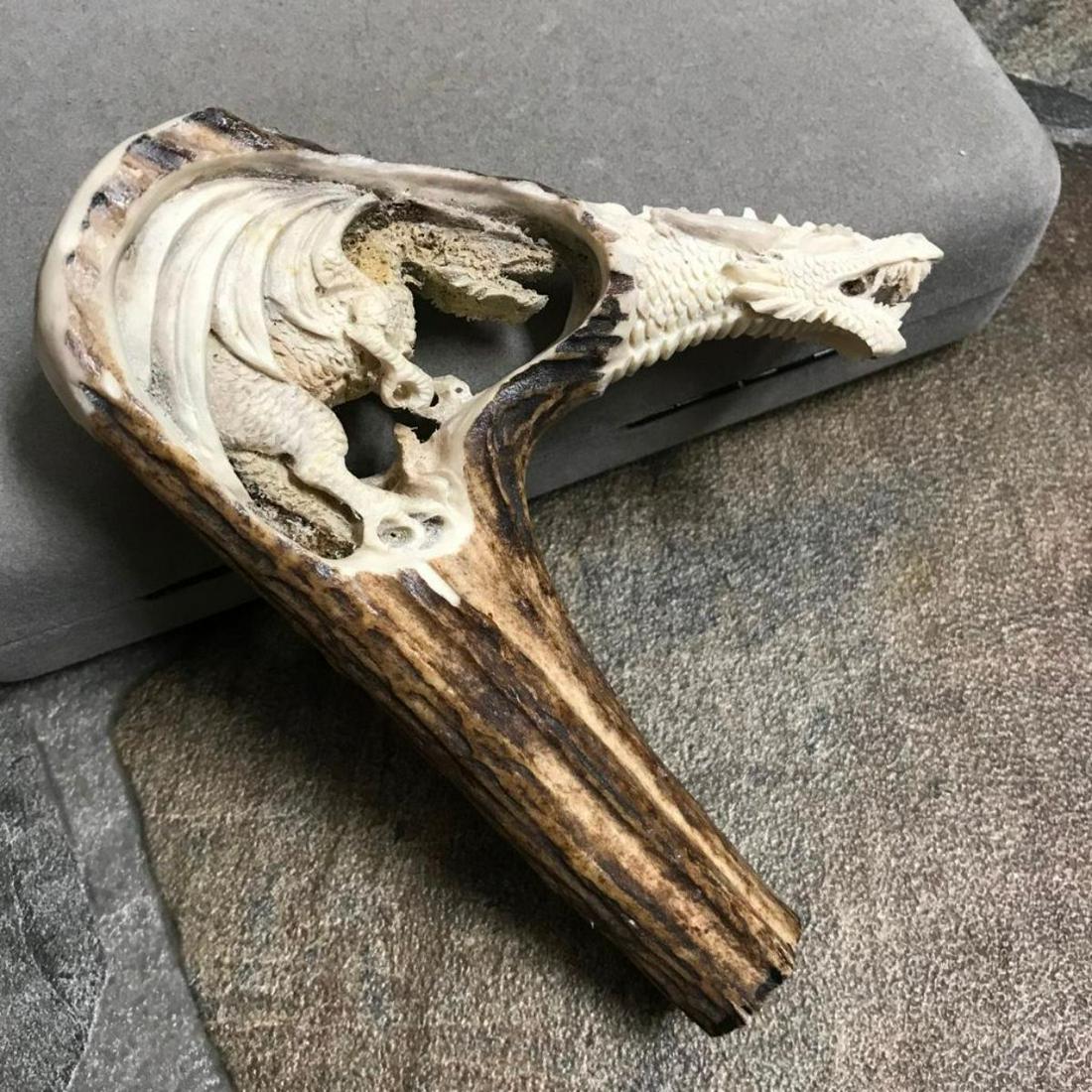 Double Dragons Carved Deer Antler Walking Stick Cane: Hand-carved shed deer antler, walking stick or cane handle. Smaller winged dragon with claws, carved inside the rounded handle of another snarling dragon head. Spectacular display piece. 4 1/2" W X 5