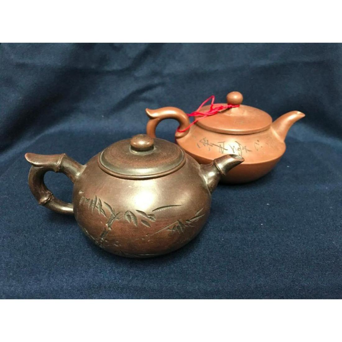 Pair of Chinese Yixing Clay Teapots: Pair of handmade Chinese yixing clay teapots with character script decorations, one with bamboo-shaped handle & spout. 