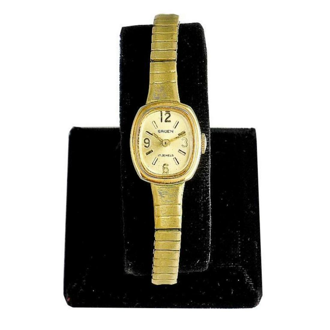 Ladies Vintage Gruen Wristwatch: Ladies Vintage Gruen 17 Jewels Wristwatch. Gold stretch band & case. Gold dial face, numbers & hands. Non-working condition. Sold as is.