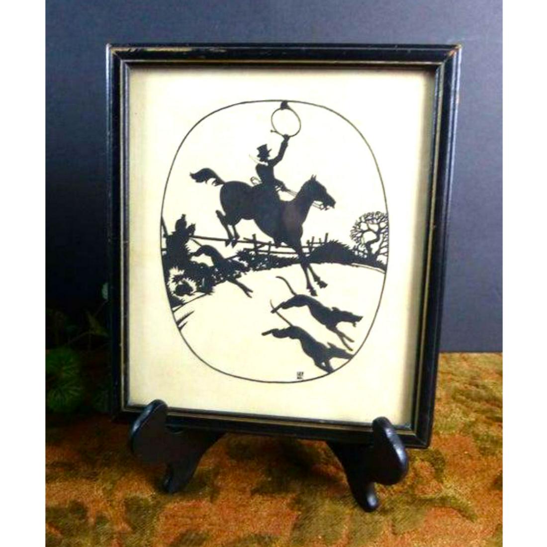 Early 1900's Signed Fox Hunt Silhouette: A framed fox hunt cut silhouette & mounted on cream parchment. The scene is in great detail with horses, dogs a fence row & trees with a humorous narrative. The hare they are hunting is hiding in the 