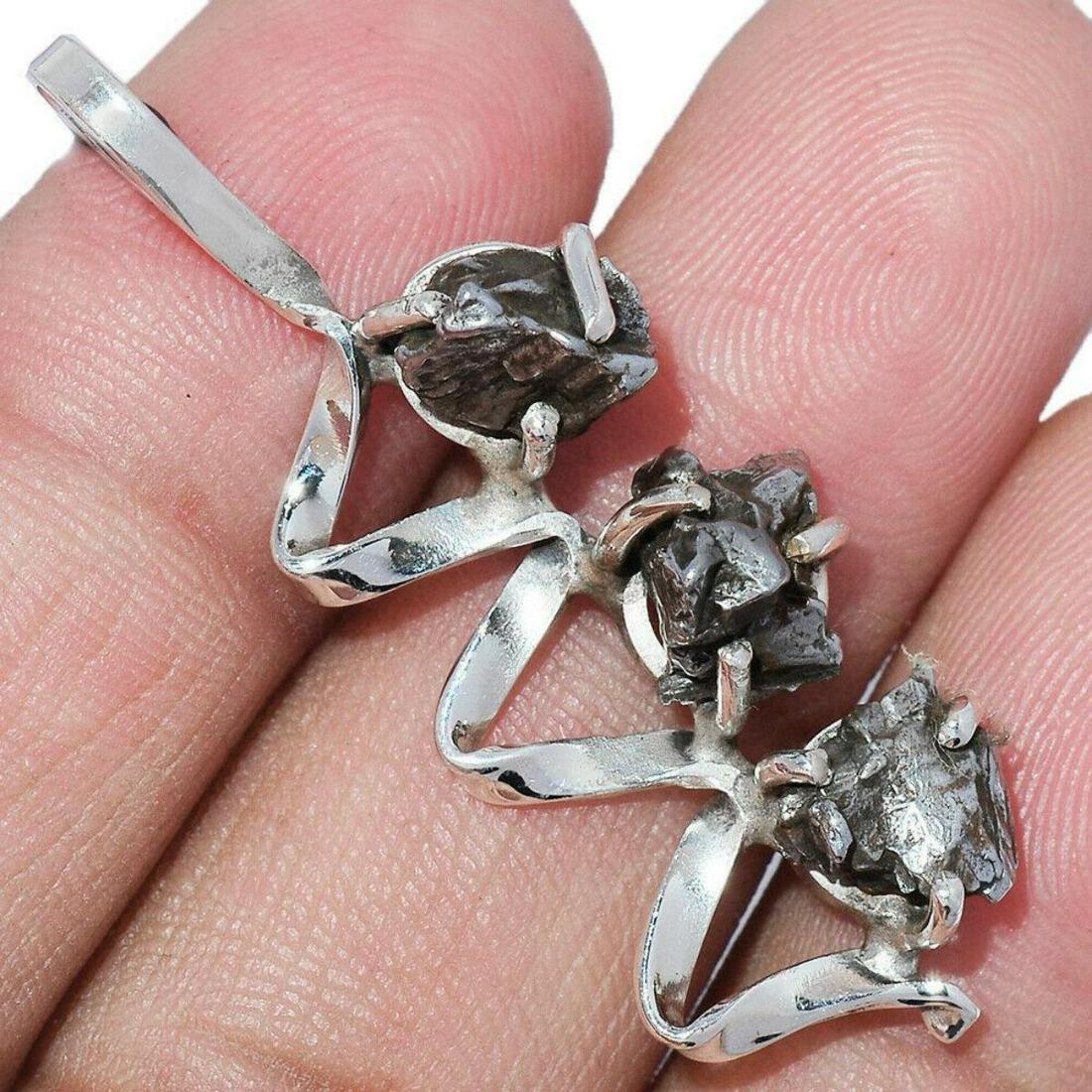 Meteorite Campo Del Cielo Sterling Silver Pendant: Three 5mm meteorites ( Campo Del Cielo, Argentina ) set into an abstract style, stamped 925 sterling silver pendant. 1 3/4" L. 5.3 grams weight, meteorites & silver. Campo del Cielo refers to a group 