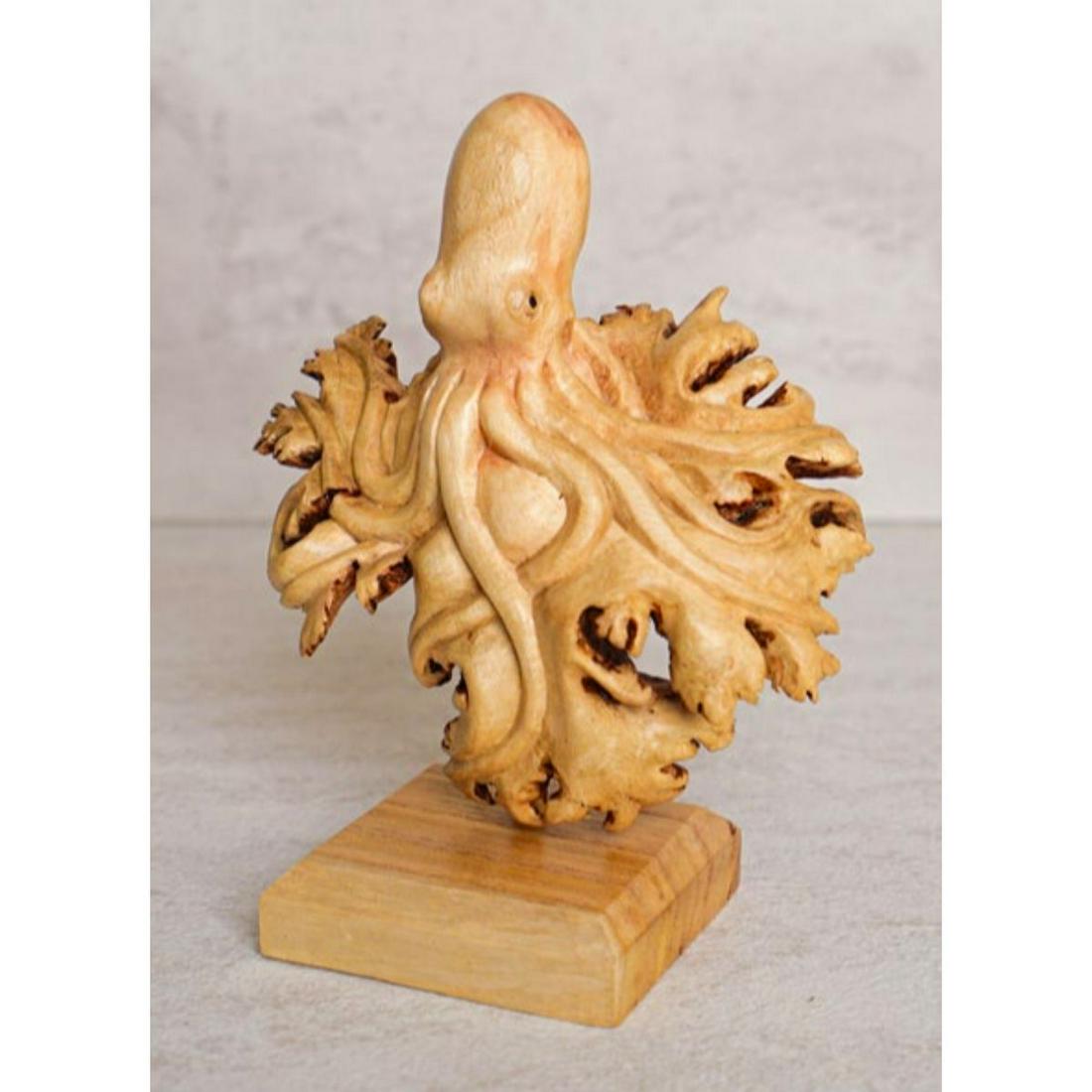 Handmade Chinaberry Wood Carving, Octopus: Handmade wood carving of an octopus, created by a skilled Balinese artisan from Chinaberry parasite wood. 6 1/2" H X 4 1/2" W X 3" D. Mounted on a matching wooden base. Parasite wood refers to the pla