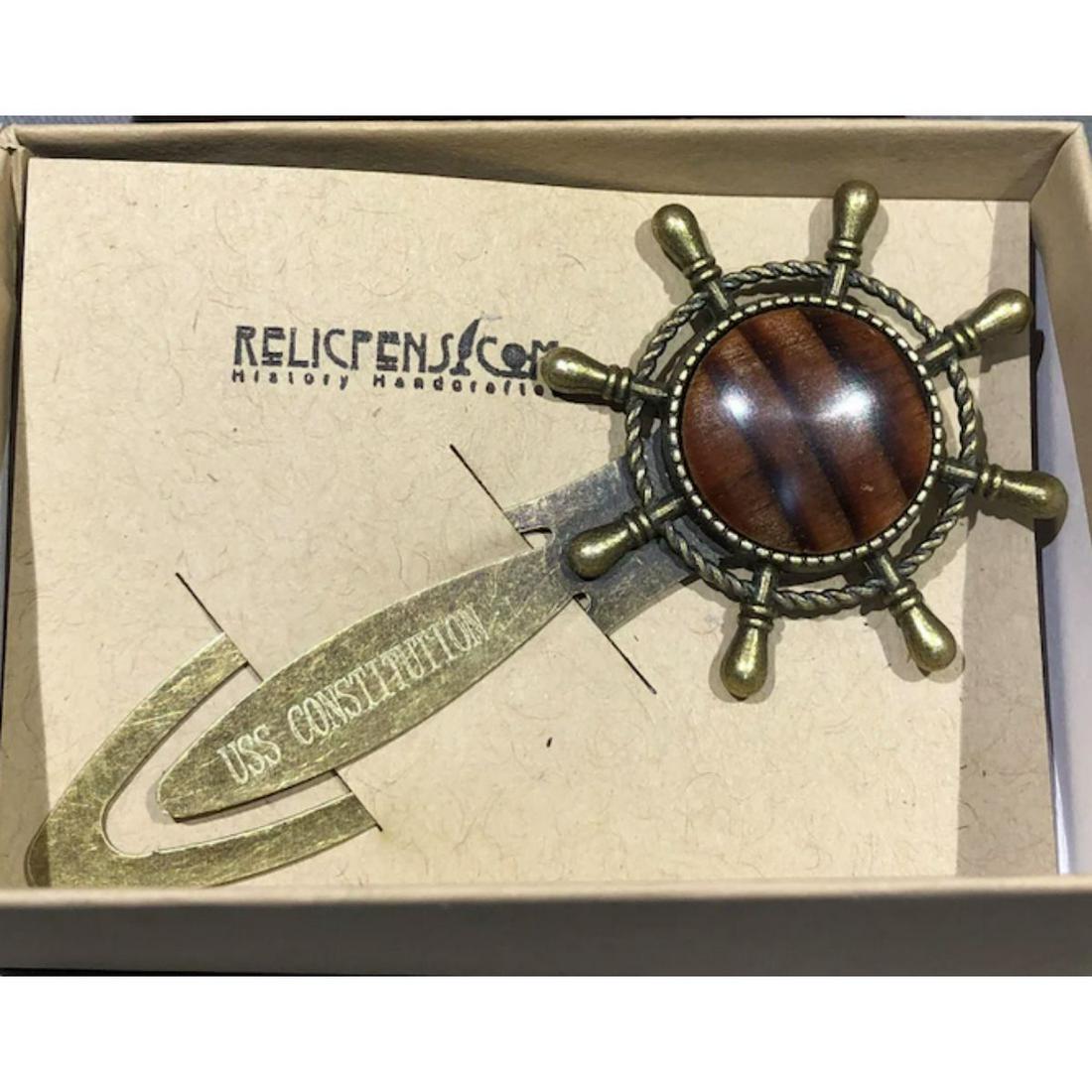 Historic USS Constitution Wood Bookmark: Ship's Wheel form bookmark, made from Fir End Grain removed off of the USS Constitution. Grain and color of oak may vary. Antiqued brass fittings. Comes with a signed COA and the pictured gift box.