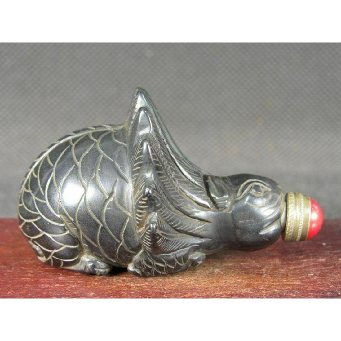 Vintage Chinese Peking Glass Beast Snuff Bottle: Vintage Chinese dark red Peking glass beast snuff bottle. Red stone top stopper. 1 1/2" H X 2 1/2" W X 2" thick.Ã‚