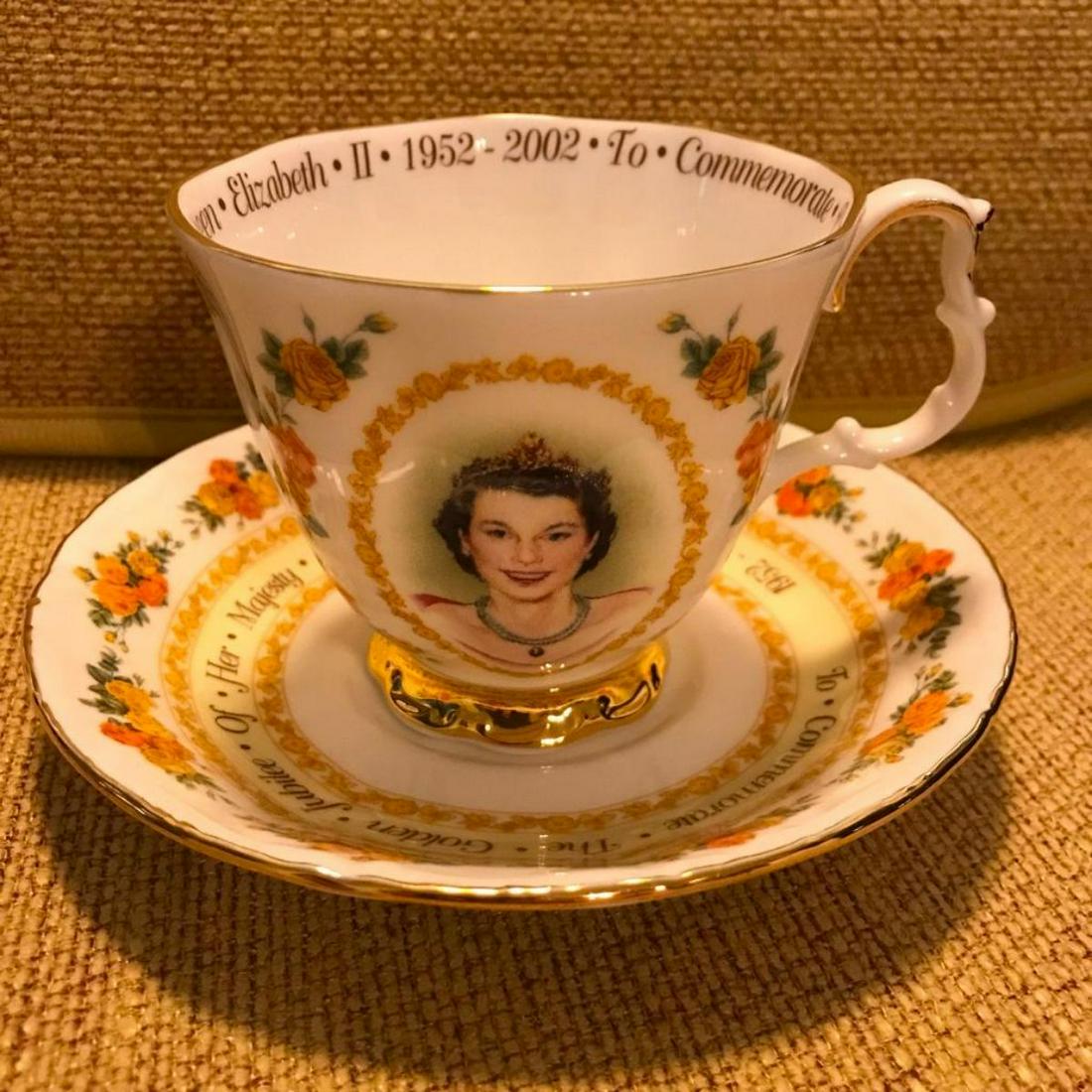 Queen Elizabeth II Golden Jubliee Commemortive Tea Cup: Royal Albert bone china tea cup with matching saucer set commemorating the 2002 Golden Jubilee of Queen Elizabeth II. The front of the cup is decorated with an image of The Queen when she was a young