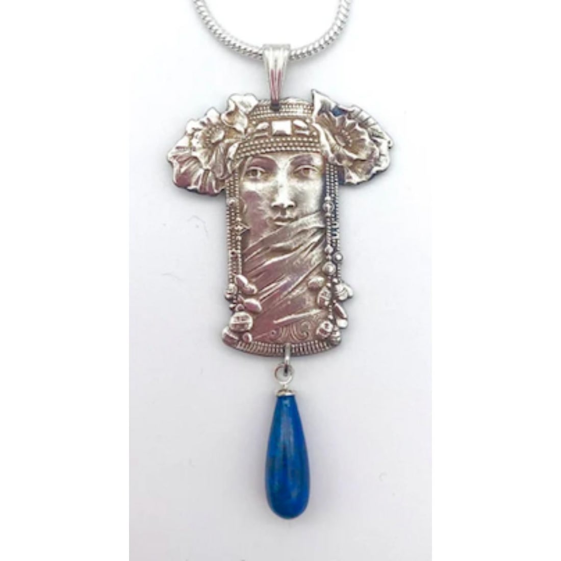 Art Nouveau Mucha Pendant Necklace: In the style of Alphonse Mucha, Art Nouveau woman, made from a vintage French stamping sourced from an old factory in Paris. Brass with silver plating embellished with a midnight blue semi precious Ei
