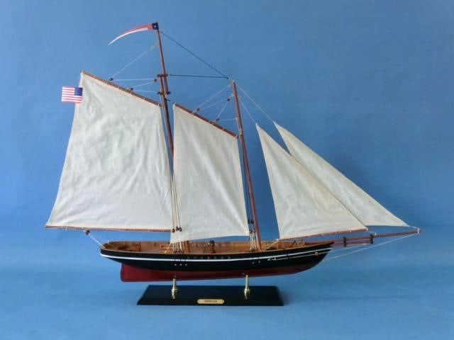 Wooden America Model Sailing Ship: Wooden America model sailing ship with cloth sails & two flags. On stand with metal nameplate. 35" L X 6" W X 28" H (1:38 scale).