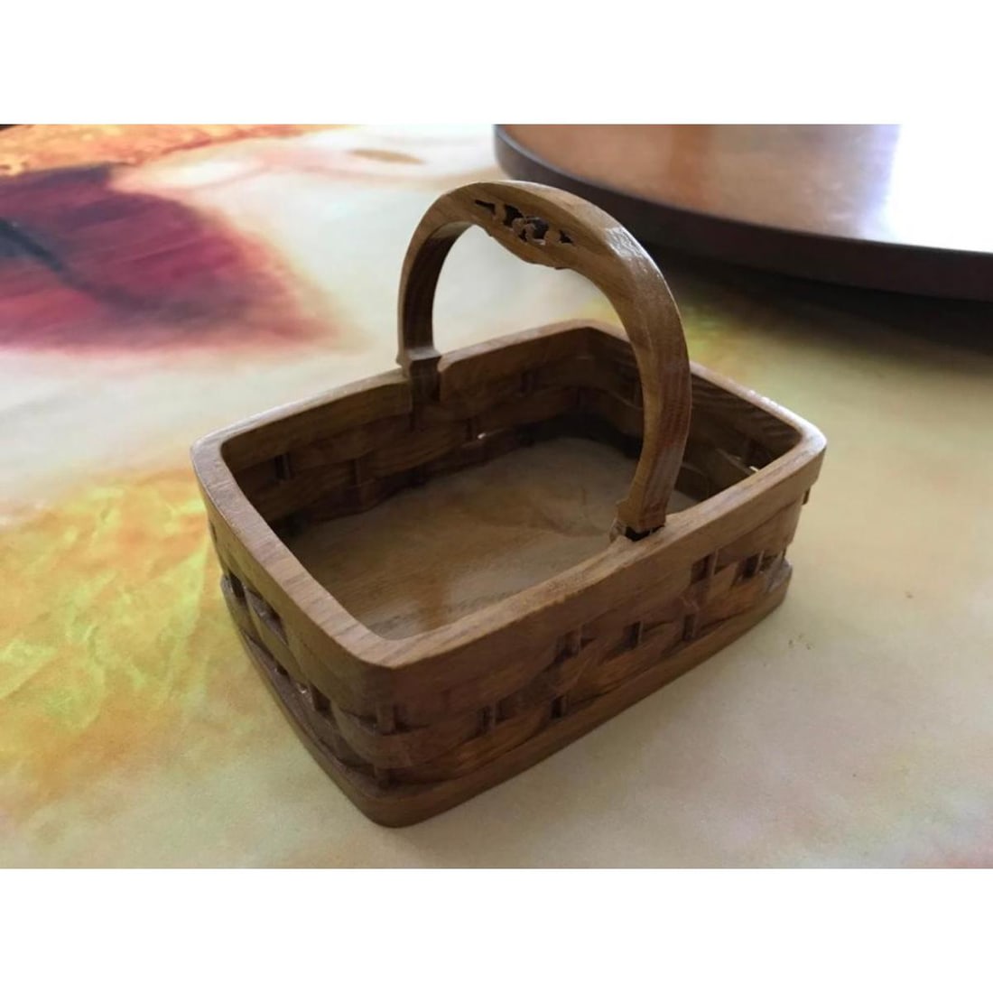 Charleston Carved Wooden Market Basket: Artisan carved woven wood market basket. Created to resemble the larger woven baskets used in the market of Charleston, South Carolina. The artist's stamp can be seen on the bottom. The little handle 