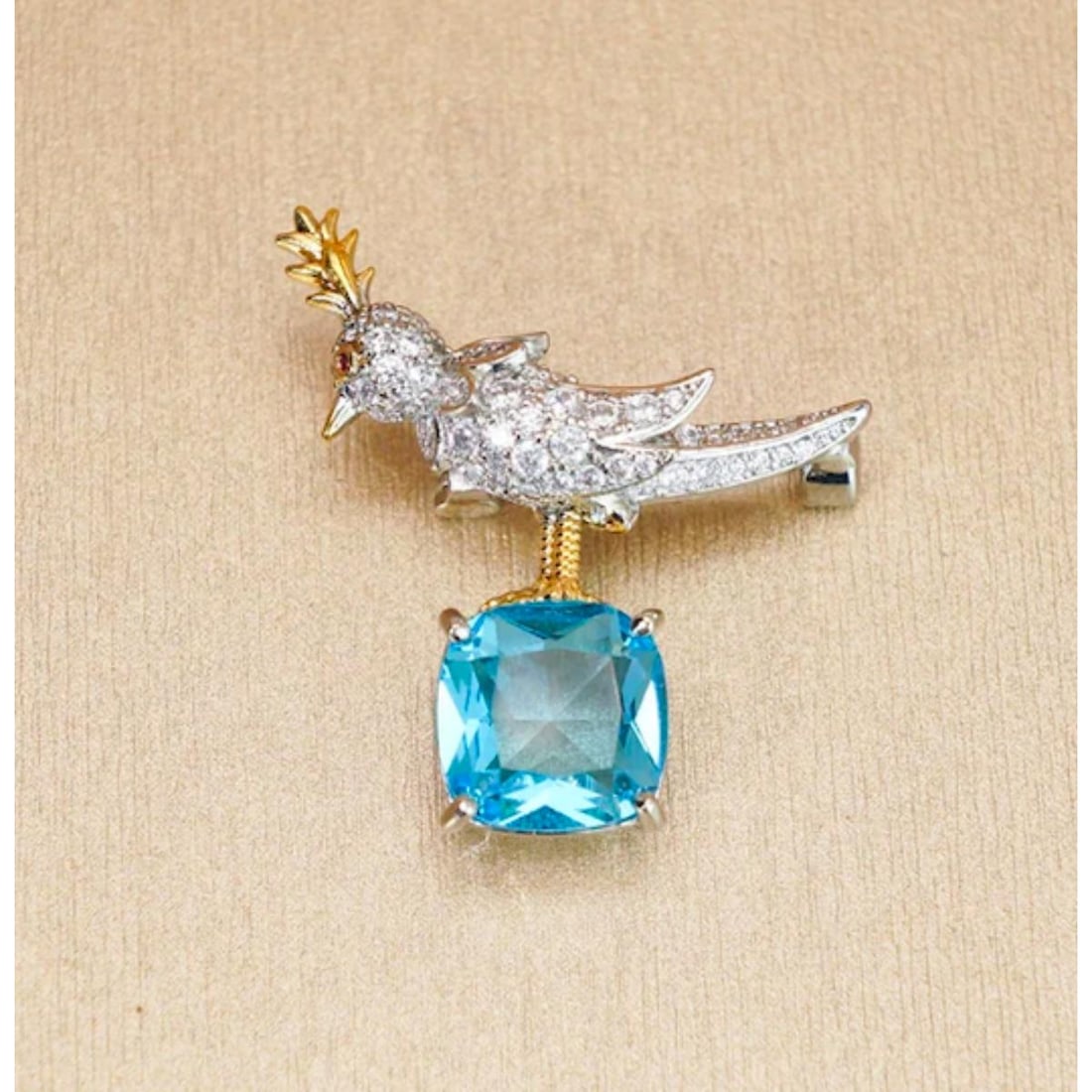 Tiffany Style Bird Brooch Pin: Aquamarine cubic zirconia gemstone ( 12mm ) cushion cut, set within a gold over copper Tiffany-style bird form brooch pin. 1 1/4" X 1 1/2".