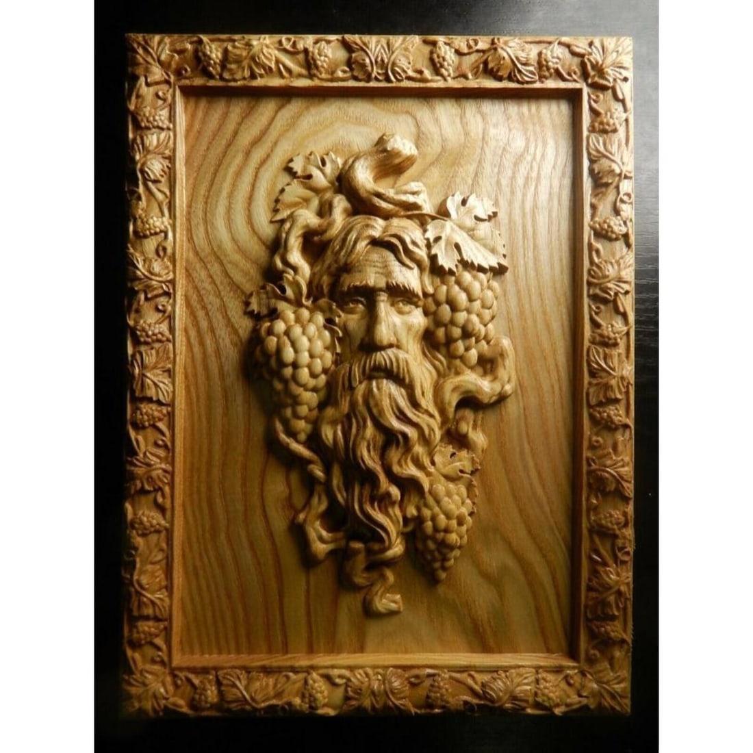 Lithuanian Carved Wooden Wine Cellar Plaque, Dionysus: Carved ash tree wooden plaque, crafted by a Lithuanian artisan. Dionysus, Bacchus, god of wine, wine cellar decoration with grapes & leaves surrounding frame. Finished with mixture of linseed oil & na
