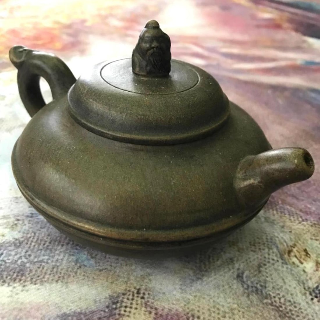 Vintage Yixing Clay Scholar Teapot: Vintage yixing clay teapot with tiny scholar on the lid. Character signature stamp on inside of lid & on the bottom of the pot. 6 1/2" L X 4 1/2" W X 3 1/2" H.