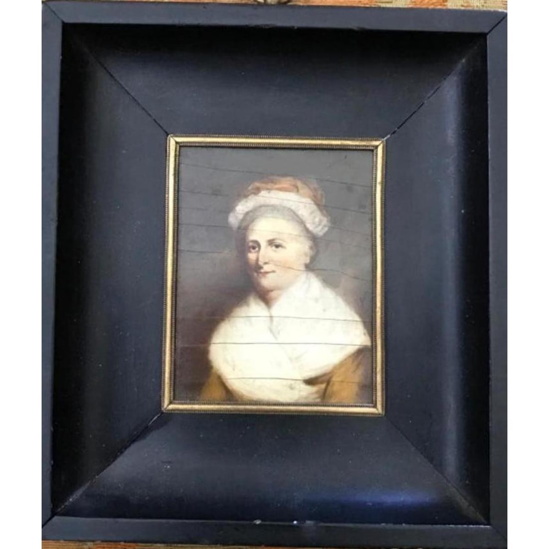 French Antique Martha Washington Portrait Miniature: Antique French oil on board miniature painting of Martha Washington in ebonized wooden frame. Cameo style hanger at the top. The backing removed to show the age of the piece with traces of French news