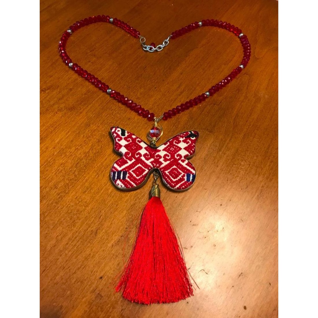 Needlepoint Artisan Butterfly Necklace: Handmade by an artisan, large size butterfly frame ( 3 1/2" X 2 1/2"), holding an antique piece of needlepoint, suspended from a 26" length chain made from 26" of faceted crystal & silvered beads. 7"