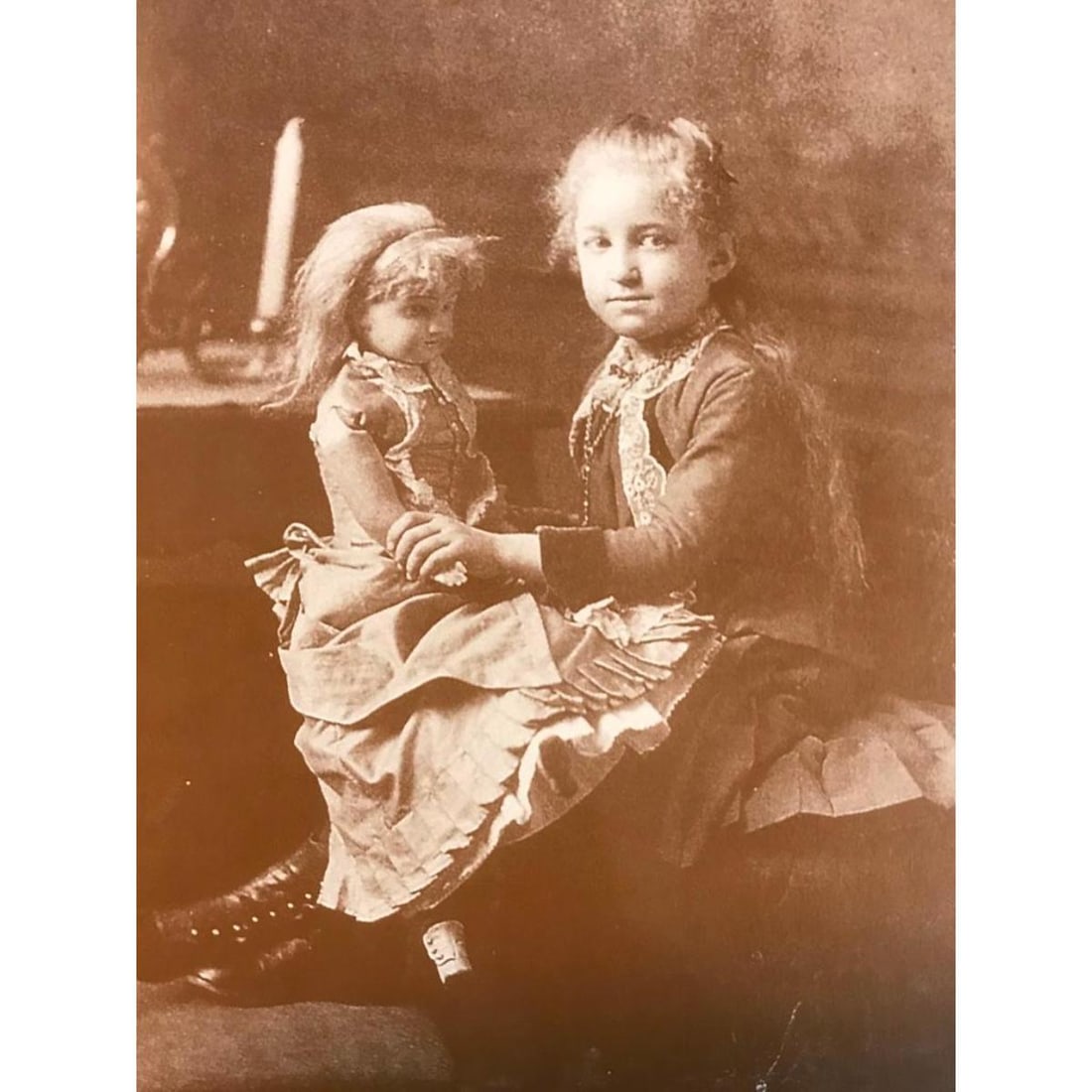 Little Girl With Doll Photo Print: Little 19th Century girl with doll, sepia-tone photo print, on heavy card stock, created in the early 1990s for The American Heritage Gallery from an original photo of the late 1800s. 8" X 10".