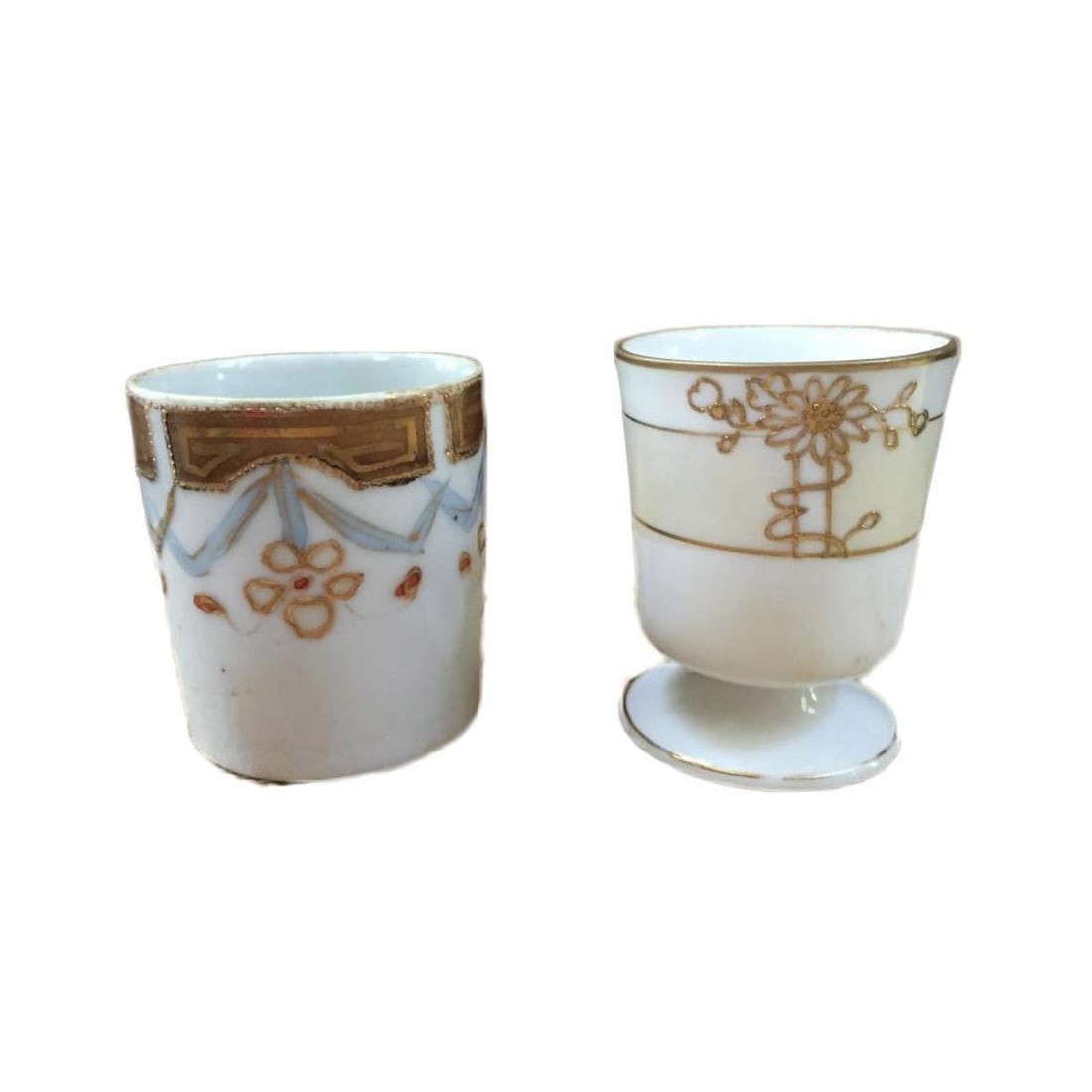 Early 1900s Pair, Nippon Gilt Floral Cups: Dainty pair of early 1900s Nippon china cups, toothpick holders, gold gilt & daisy pattern Morimura Moriage pedestal with Nippon blue rising sun stamp on the bottom. Both approx 1 3/4" D & 1 1/4" H.