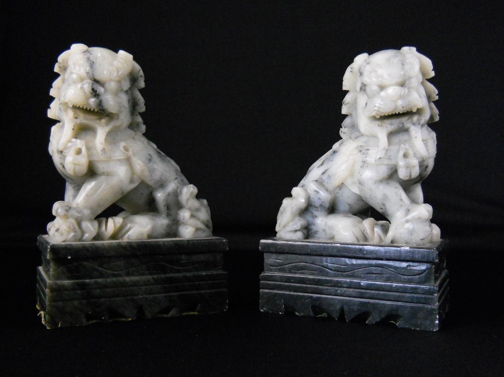 Pair of Chinese carved grey Foo Dogs: A pair of Chinese carved grey soapstone Dogs of Foo on a dark grey rectangular base, height 17.5cm.