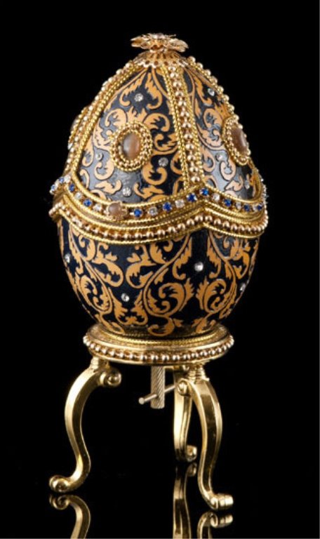 Faberge Inspired Elegant Brocade Egg: With a look of regal elegance, this musical egg features an intricate brocade pattern etched into the shell. The black enamel background of the egg and sparkling clear crystals beautifully contrast wi