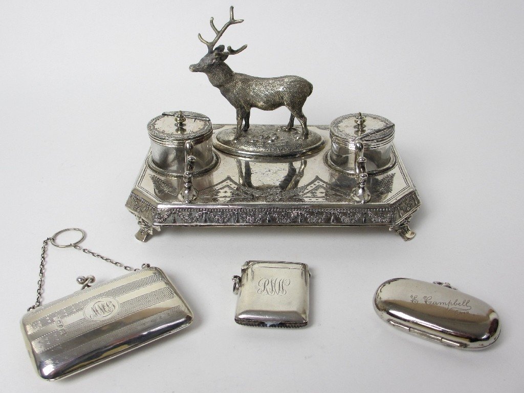 Group of silver plate decorative objects.: Group of silver plate decorative objects. A silver plated inkstand with stag surmount, a silver purse, Birmingham 1910, a silver vesta, Birmingham 1914 and a white metal sovereign case (4). A Silver p