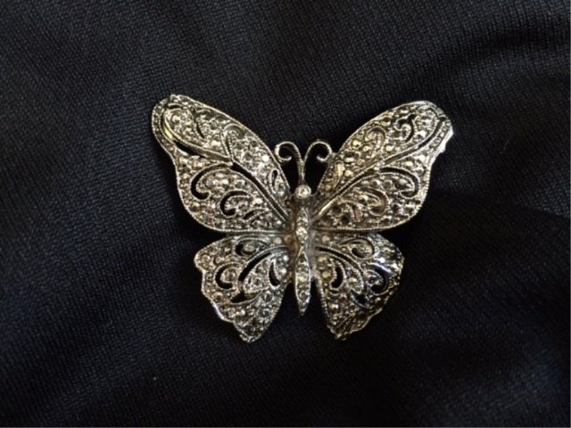 Vintage Silver Marcasite Butterfly Brooch: Vintage Silver & Marcasite Brooch. Unmarked. Brooch has 3 tiny clear inset stones in the center body of the butterfly. The back is unmarked so most likely silver toned metal rather than sterling. 1 7/