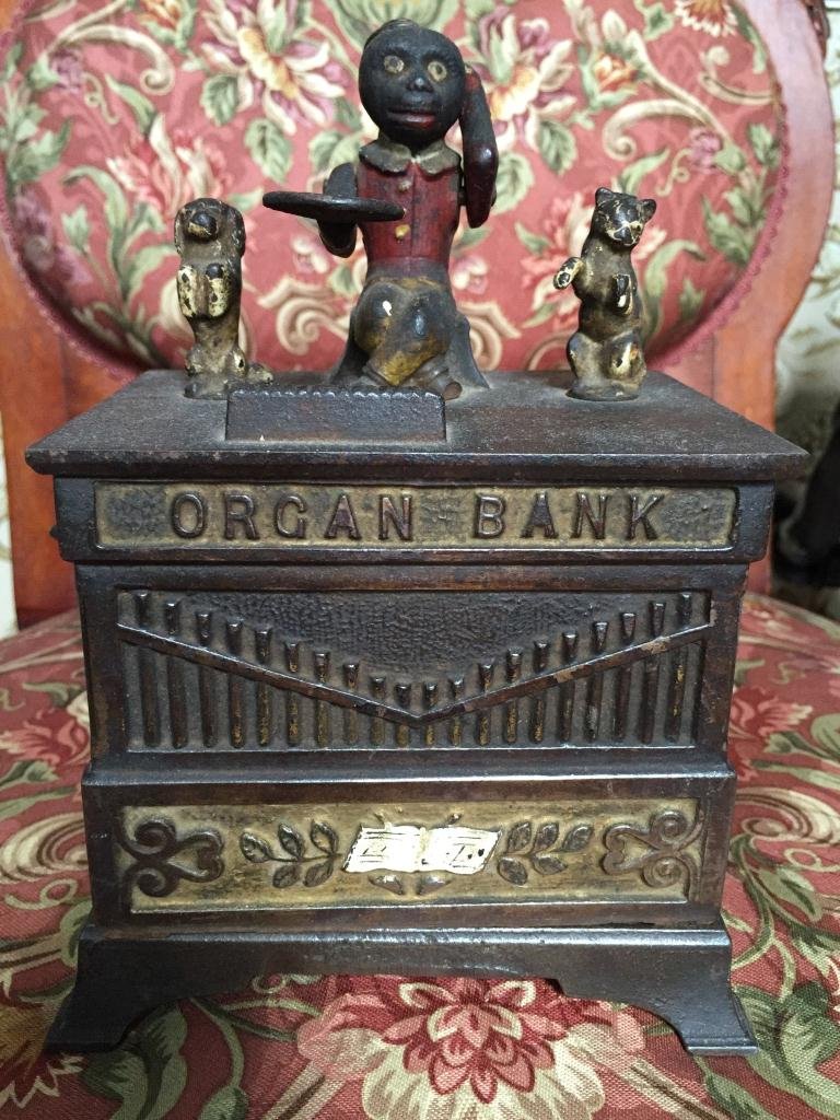 c1882 Mechanical Cast Iron Organ Bank: Original c1882 cast iron organ bank, a dog & cat flanking an articulated monkey holding a paddle for the coin. When the crank was turned, the coin would fall off the paddle & then deposited into the s