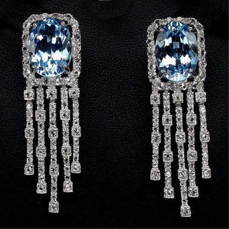 12ctw Blue & White Topaz Chandelier Earrings: Fabulous Swiss blue & white topaz chandelier earrings. Each Swiss blue topaz focal stone weighs approx 6cts ( 14 X 10mm ). Over Post backs. 14kt white gold over sterling silver. 48mm length, 15mm widt