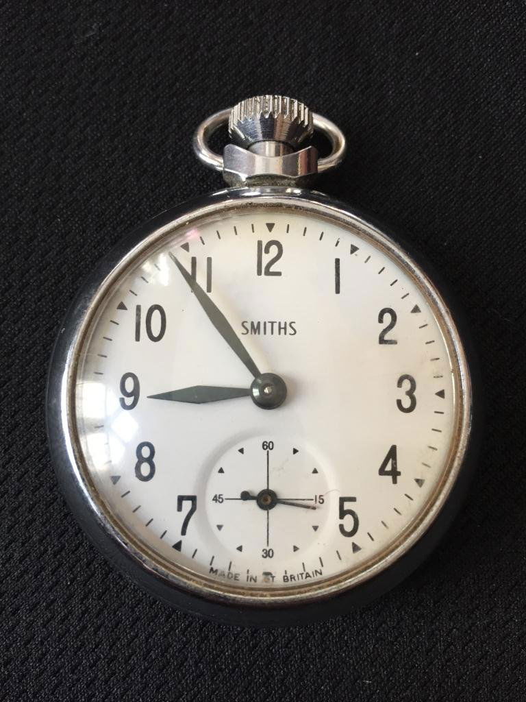 Vintage Mid Century Smiths Pocket Watch: Vintage 1950's British Smiths pocket watch. Made in the UK. Silver case, ivory face color, open face closure, mechanical hand winding. 50mm analog display. In working condition