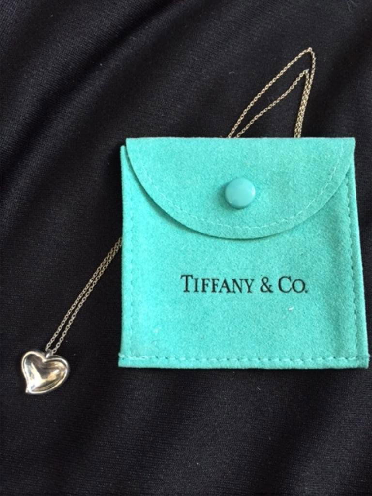 Sterling Tiffany & Co. Elsa Peretti Heart Necklace: .925 Sterling Silver, stamped Tiffany & Co. Spain, signed Elsa Peretti from the Carved Heart Collection. 17" length. Comes with the original Tiffany & Co. blue suede pouch.