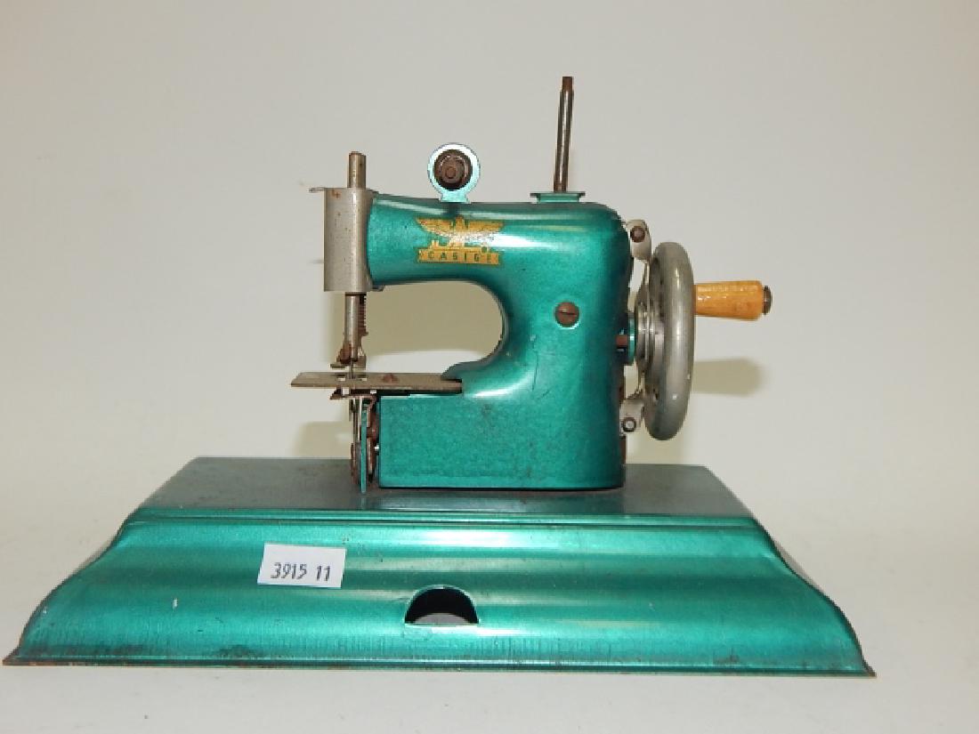 CHILD SEWING MACHINE: 6 AND 1/2" TALL, 8 AND 1/2" LONG, 5" WIDE.