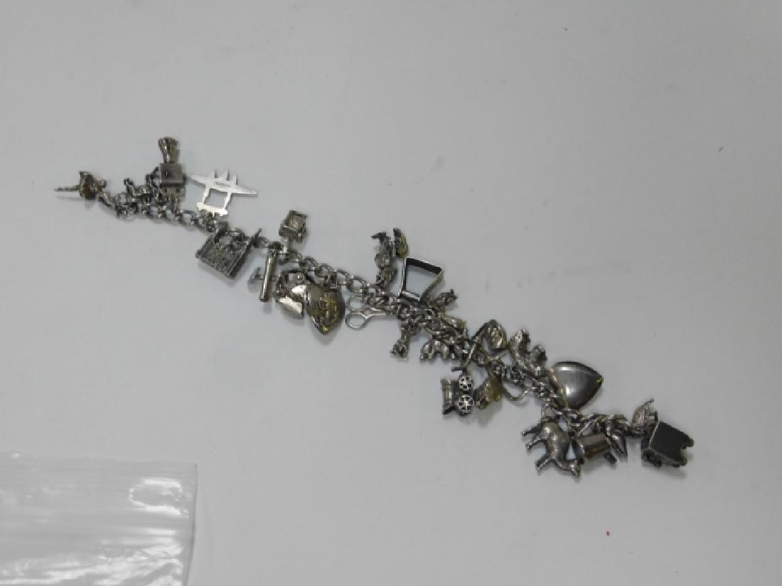 CHARM BRACELET: VARIOUS CHARMS, BALLERINA, MOVIE/CAMERA EQUIPMENT, BUILDINGS, ANIMALS, SCISSORS, HEART, CARRIAGE, SMOKING PIPE AND SO MUCH MORE.SOME PCS MARKED STERLING.