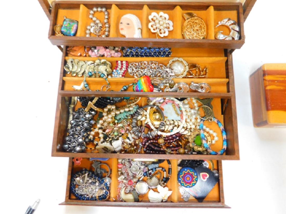 COSTUME JEWELRY WITH BOX: LARGE ASSORTMENT OF COSTUME JEWELRY WITH A JEWELRY BOX. DAMAGE TO TOP JEWELRY SECTION. PINS, PENDANTS, BRACELETS, KEY CHAIN, JEWELRY PIECES AND PARTS.