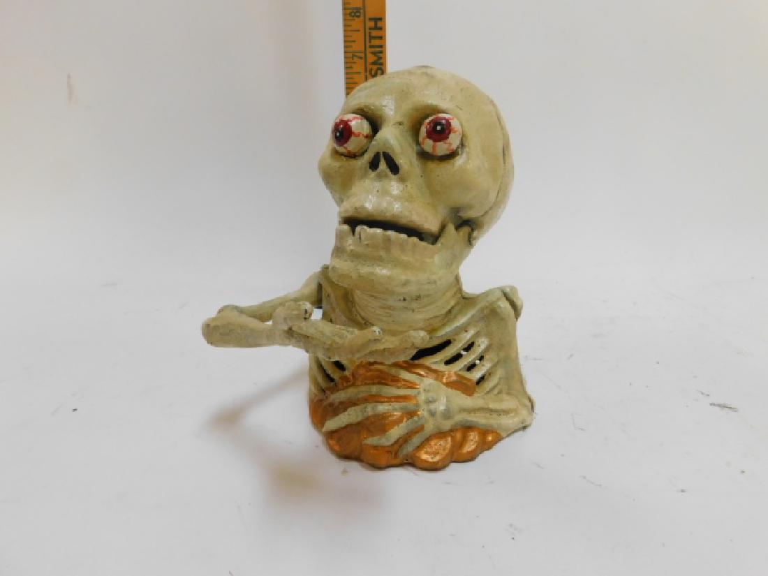 MODERN, CAST IRON MECHANICAL SKELETON BANK: WORKS. EYES BUG OUT.