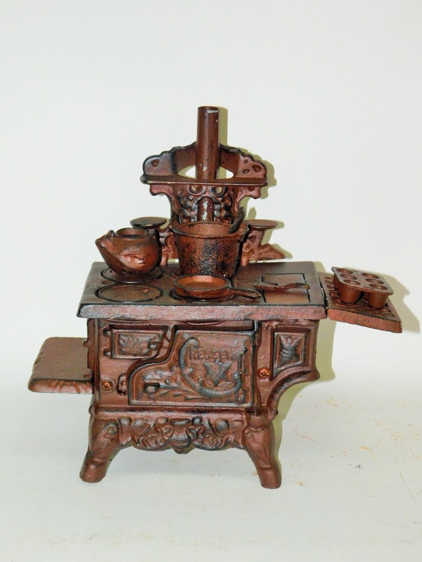 CAST IRON DOLL STOVE: MODERN. APPROX 10" TALL. WITH POTS, UTENSILS, AND MUFFIN BAKING PAN