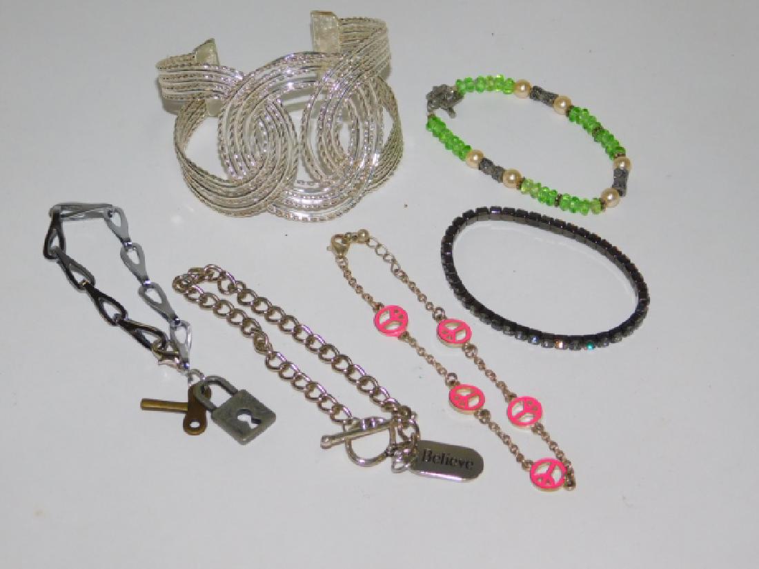 SIX COSTUME BRACELETS: LARGE CLASSIC CUFF BRACELET, ALONG WITH BEADED, TENNIS, AND CHARM BRACELETS