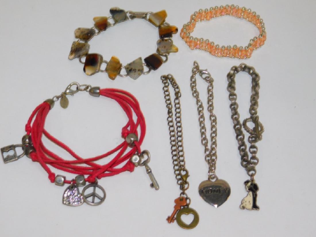SIX COSTUME BRACELETS: INCLUDES MULTIPLE STRAND CORD CHARM BRACELET, A VERY PRETTY NATURAL STONE BRACELET, ALONG WITH SINGLE CHARM BRACELETS.