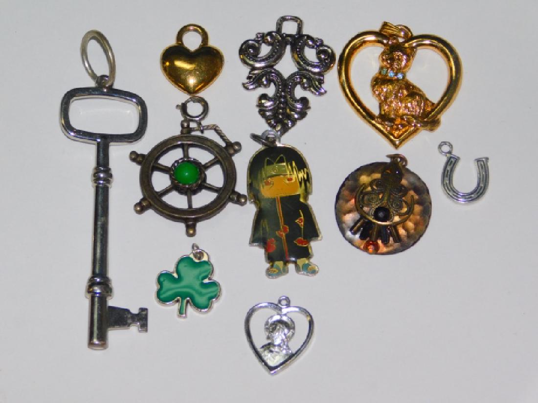 TEN COSTUME PENDANTS: KEY, CLOVER, HORSESHOE, HEART, SHIP WHEEL, AND MORE.