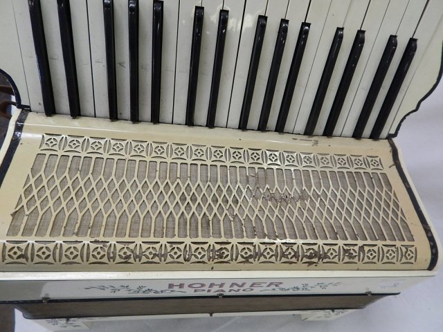 ACCORDIAN HOHNER PIANO: WITH CASE. DAMAGE ON GRILL.