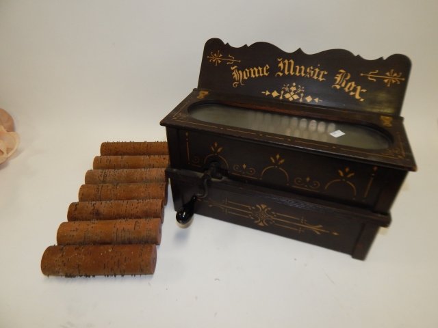 HOME MUSIC BOX WITH SEVEN EXTRA ROLLERS: BELLOWS ARE GOOD. TOP VACUUM IS NOT HOOKED UP. COMPLETE WITH 7 ROLLS. 14" X 12" X 11.