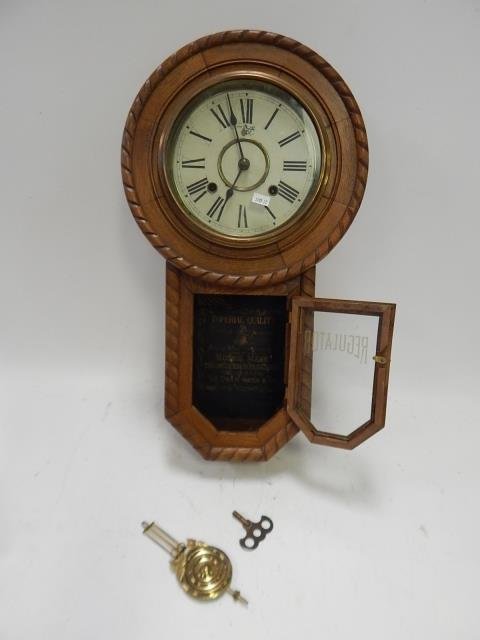 REGULATOR CARVED WALL CLOCK: 22" TALL. KEY AND PENDULUM. SOLD AS IS.