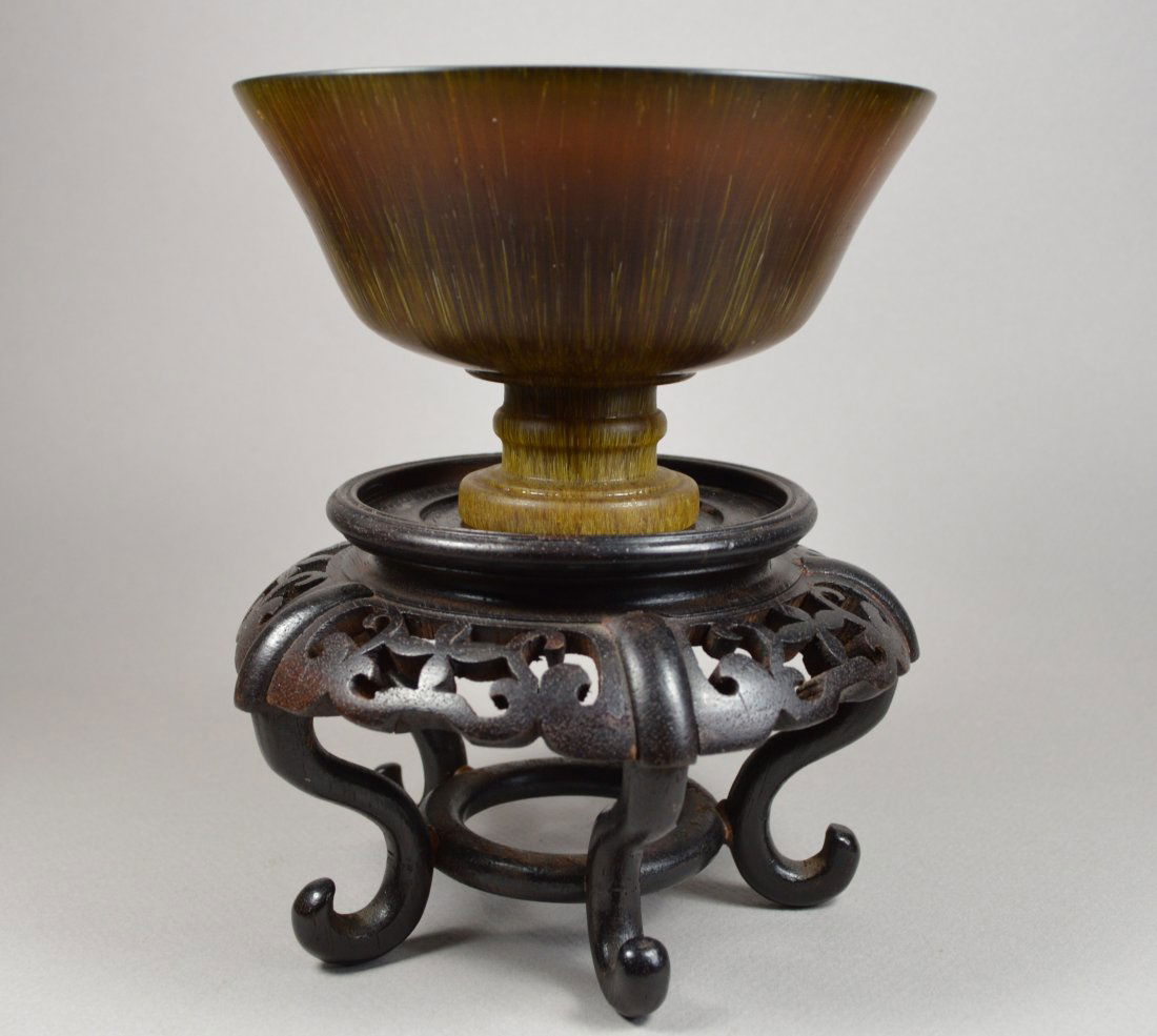 A LARGE VINTAGE RHINOCEROS HORN CARVED GOBLET: A large and finely carved rhinoceros horn footed vintage wine goblet, ambery color with very fine smooth carving. Size 4.6 D x 3 H inches, 247 grams, exc cond. Stand not included.