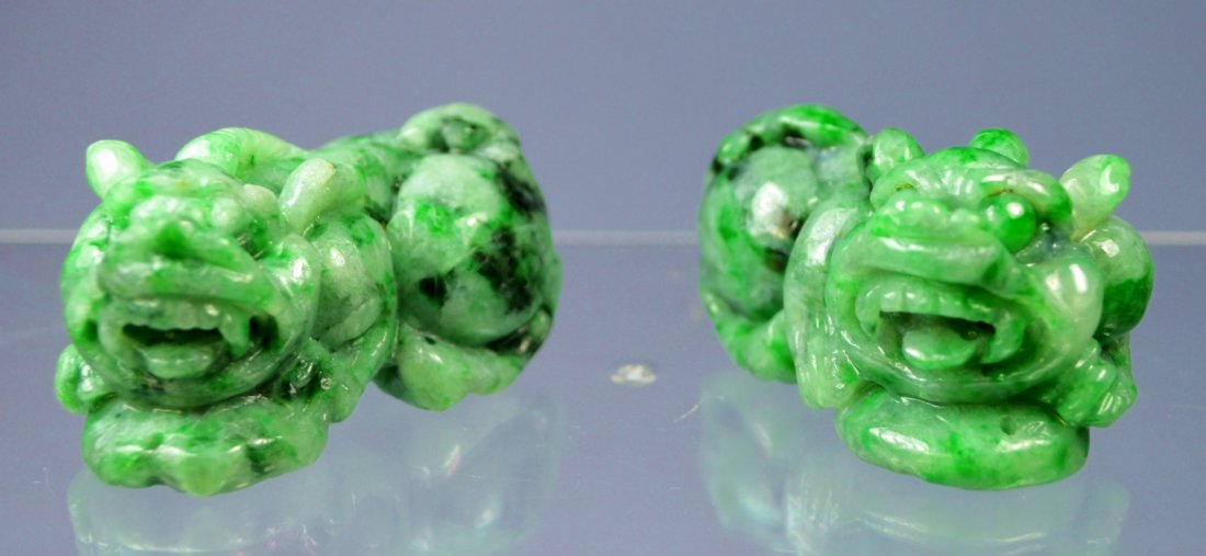 CHINESE GR A CARVED EMERALD GREEN JADE FOO DOGS (PR): A stunning pair of Chinese emerald green carved foo dogs, grade A. 50 x 30 x 30 mm each. Carved as a mirror reflection pair. They could be used as amulets also. Excellent condition. Private collection