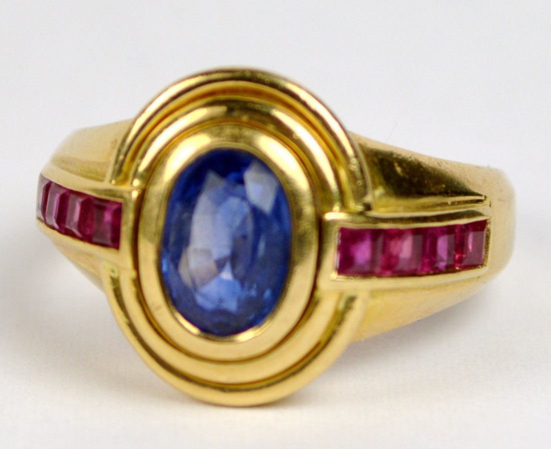 RING, 18KT YELLOW GOLD SAPPHIRE AND RUBIES: A nice ring 18 KT yellow gold, 6.8 gr, size 7, center stone is natural very translucent could be a Ceylon sapphire. Excellent condition.