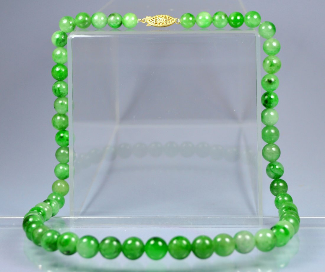 CHINESE TOP GRADE A GREEN JADE BEAD NECKLACE 14 KT: A stunning and rare Chinese carved green apple colored Grade A jade bead neklace. 14 KT gold hallmarked clasp. Graduated bead sizes 7 to 10 mm. Approx 20 inches long. Excellent translucency and polish
