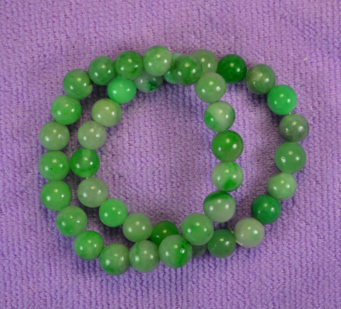 CHINESE TOP GREEN JADE BEAD BRACELELTS (PAIR): Chinese top carved jade bracelets (pair) each 9 mm bead size and 17 cm length. Excellent condition. From a jeweler's estate,