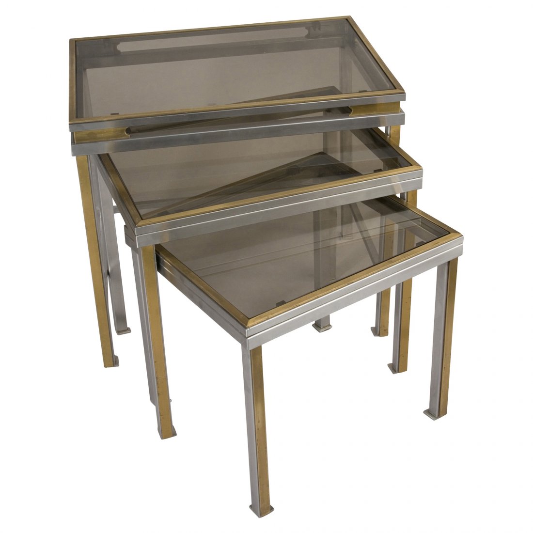 Guy Lefevre Nest: Suite of three chrome and brass nesting tables, the rectangular surface supported by column shaped legs, with lightly tinted glass tops, by Guy Lefevre for Maison Jansen, French 1970s. big: 19 5/8 x 1