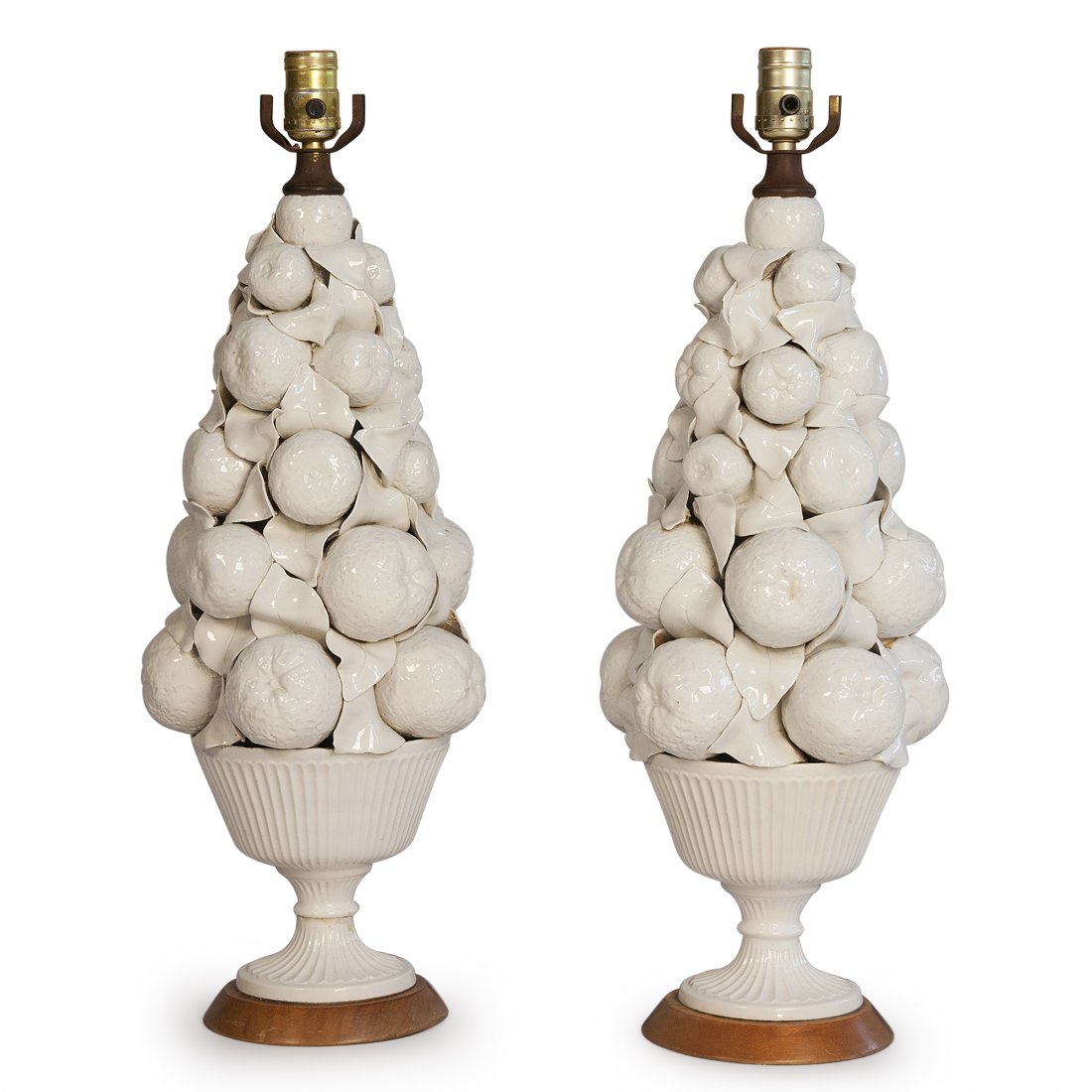 Blanc de Chine Table Lamps, Pair: Pair of white ceramic lamps, a tall mound of fruit forms in a basket, the basket footed, with circular wood base. Overall height to top of socket 24 1/2 in, largest diameter of base 9 in, diameter at 