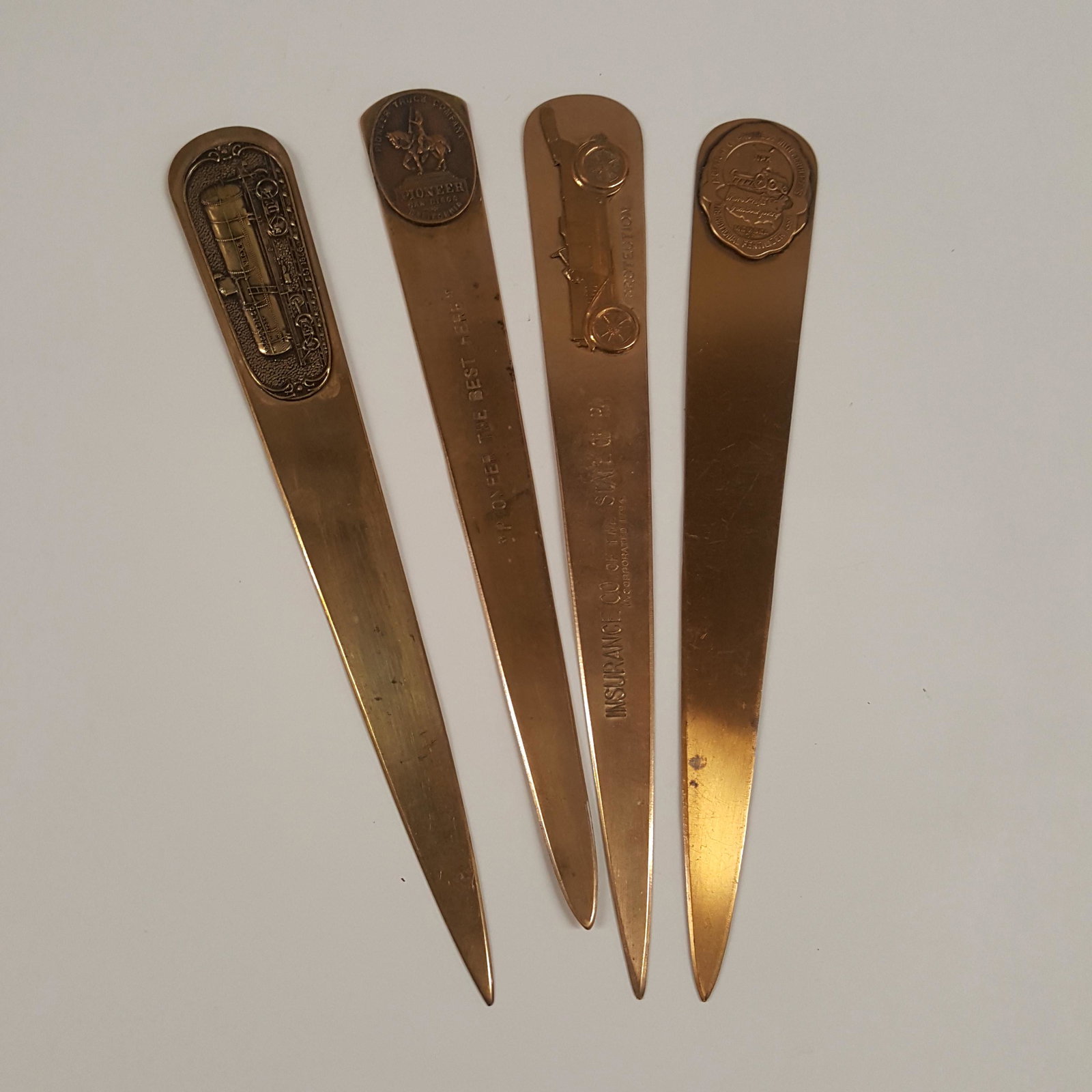 Four BRASS LETTER OPENERS, raised emblems on each,: Four BRASS LETTER OPENERS, raised emblems on each, Advertising Automobiles, Train Transportation and polish