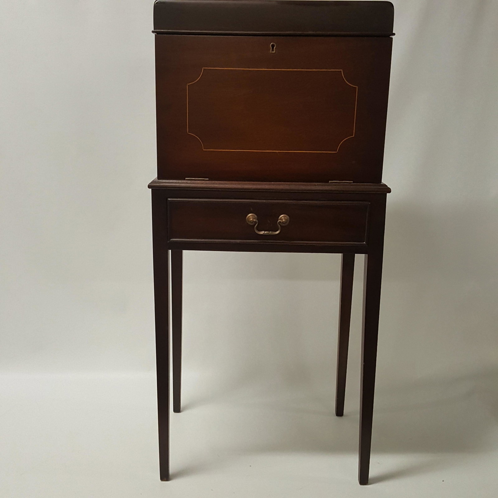 HEPPLEWHITE STYLE MAHOGANY AND LINE INLAID LIQUOR: HEPPLEWHITE STYLE MAHOGANY AND LINE INLAID LIQUOR CABINET, with lift top, fitted interior and drop front and lower drawer on tapering legs. 20th century