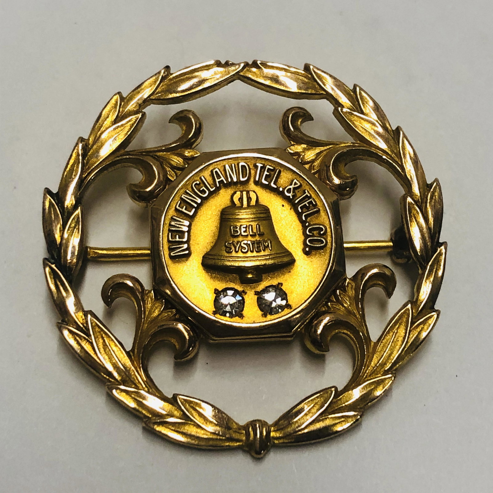 10K gold filled New England and Telegraph Anniversary: 10K gold filled New England and Telegraph Anniversary pin with two diamond chips, a gold and diamond set commemorative pen-raised center in New England tel and tel company with two small diamonds back